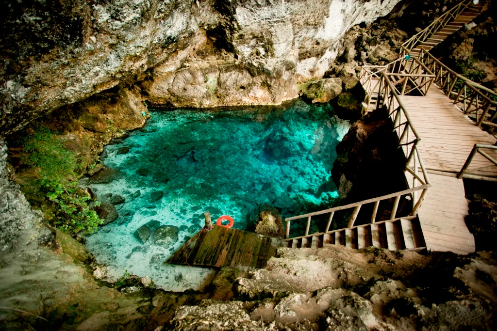 Turquoise cenote surrounded by tropical cliffs at Scape Park, Cap Cana