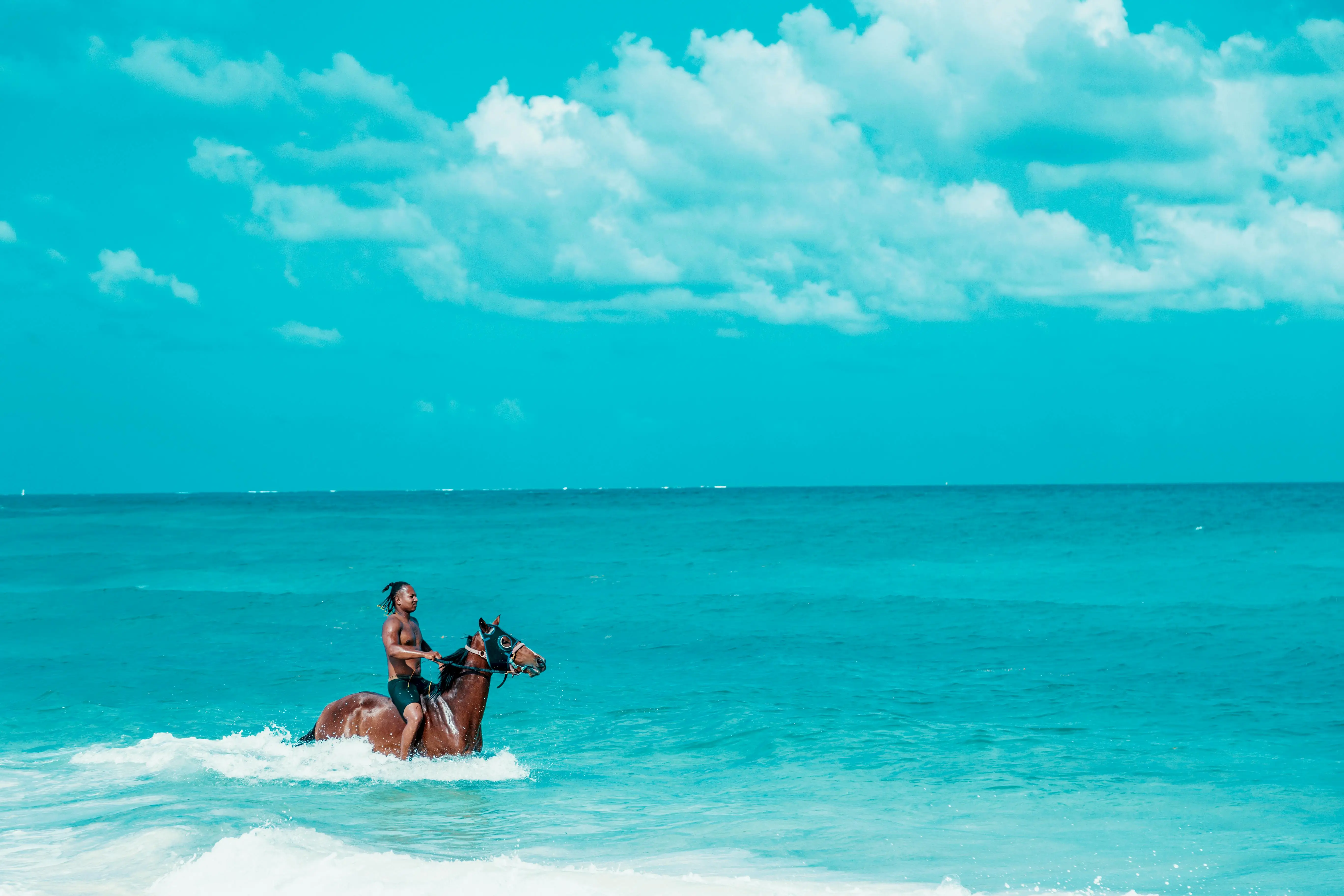 Horseback rider in turquoise water on a Punta Cana beach